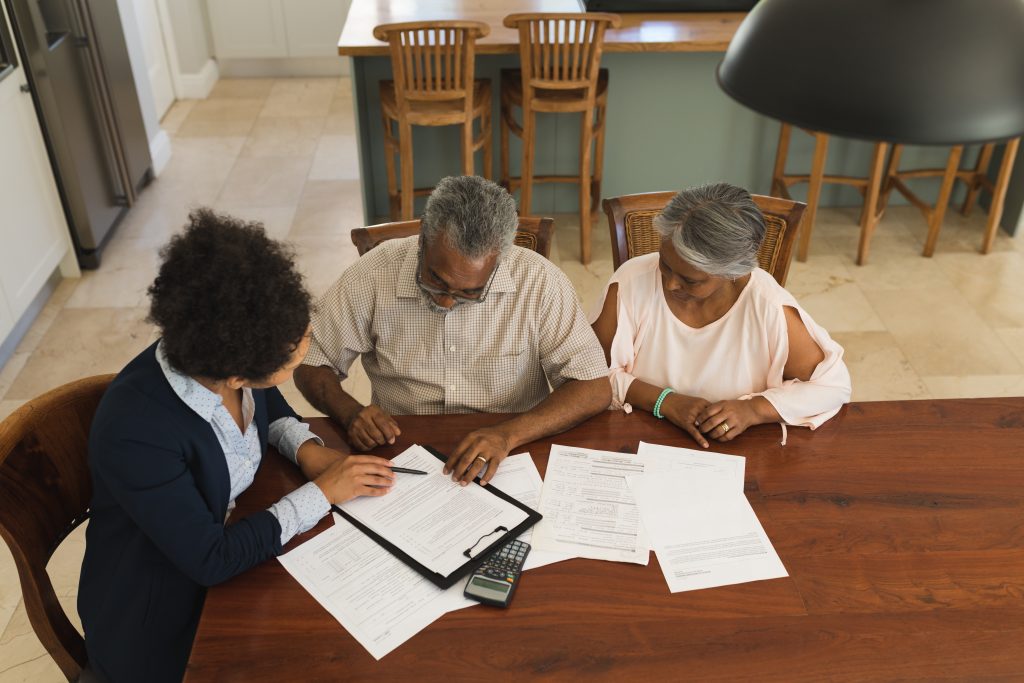 People reviewing and signing documents together at a table