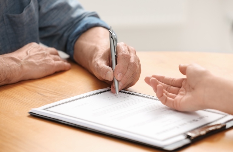 Senior man is reviewing documents with lawyer